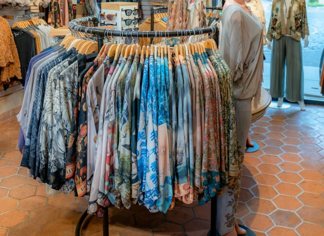 A round rack of tops in bold prints: florals, blue landscapes, and scenes from old maps