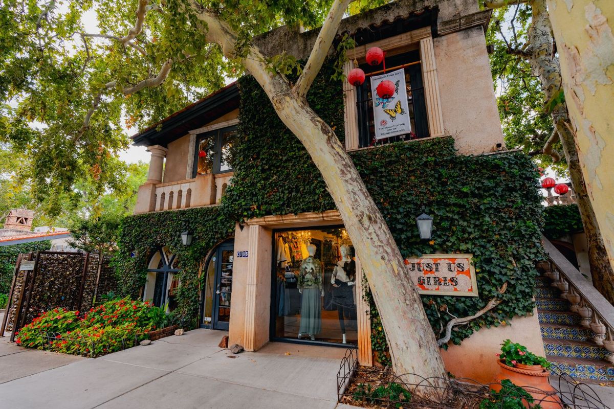 The ivy-covered Just Us Girls storefront on Calle Miller, with the love-lock gate at the left